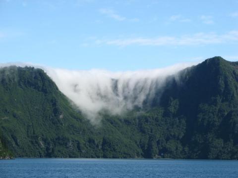 Clouds pouring over a mountain