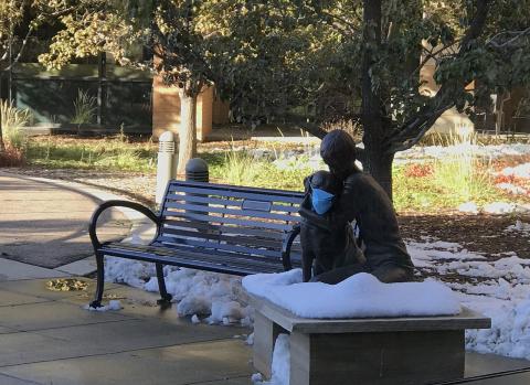 A child, a dog, and a mask - statue at Boulder Community Hospital