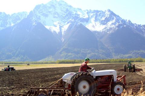 Farmers plowing a field in Palmer, Alaska